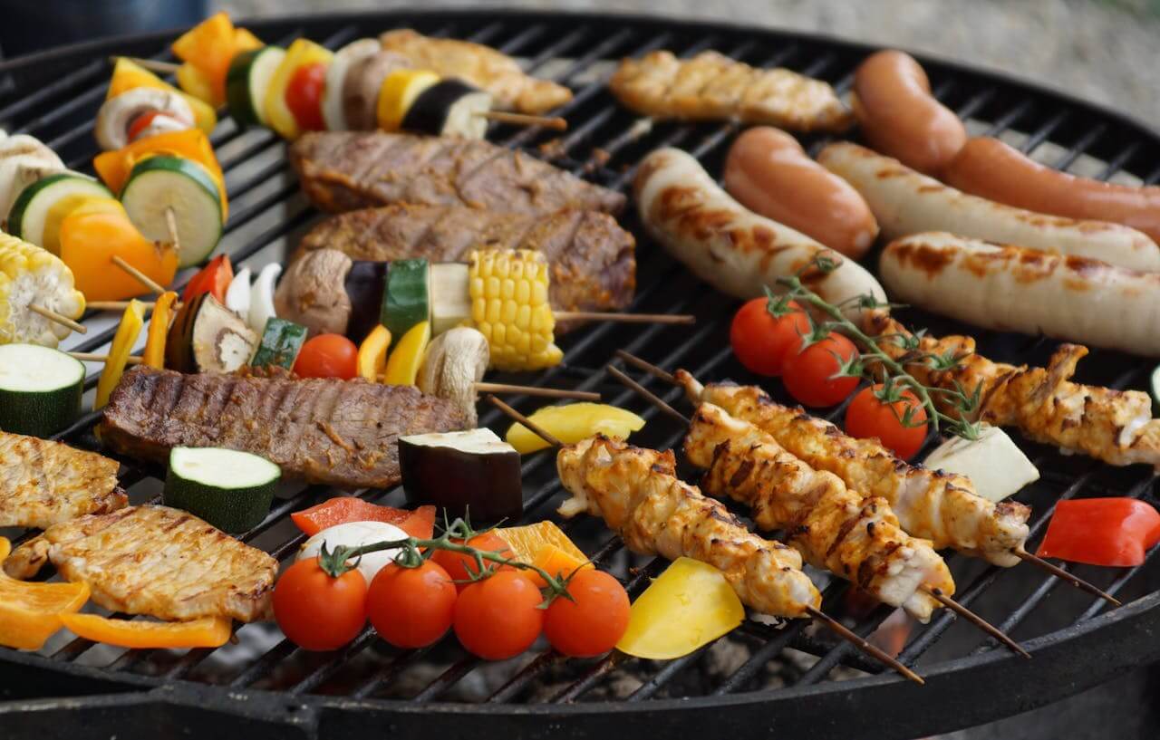 A grill will meat and vegetables on it