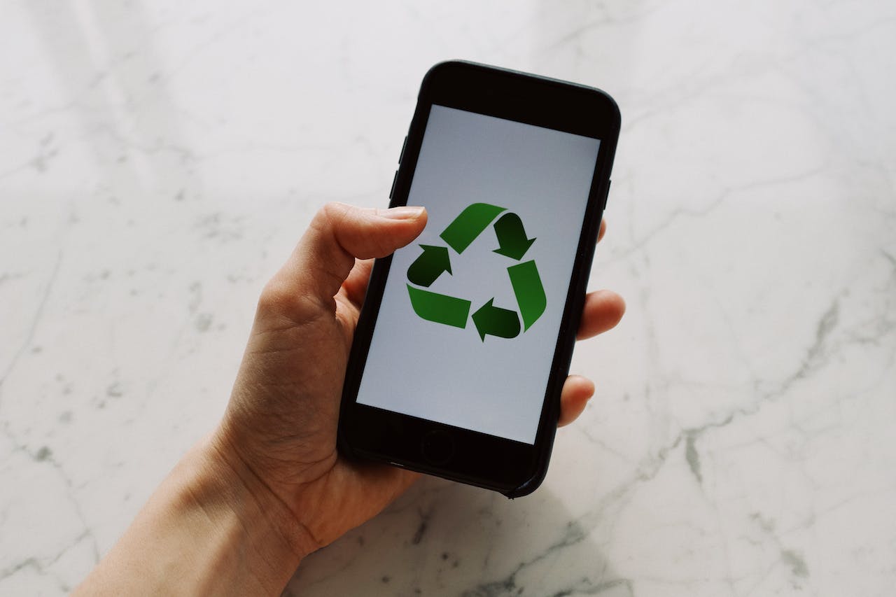 Smartphone display with the recycle logo on the screen