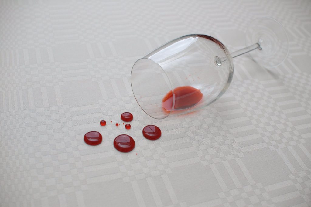 Drops of spilt red wine of a white carpet