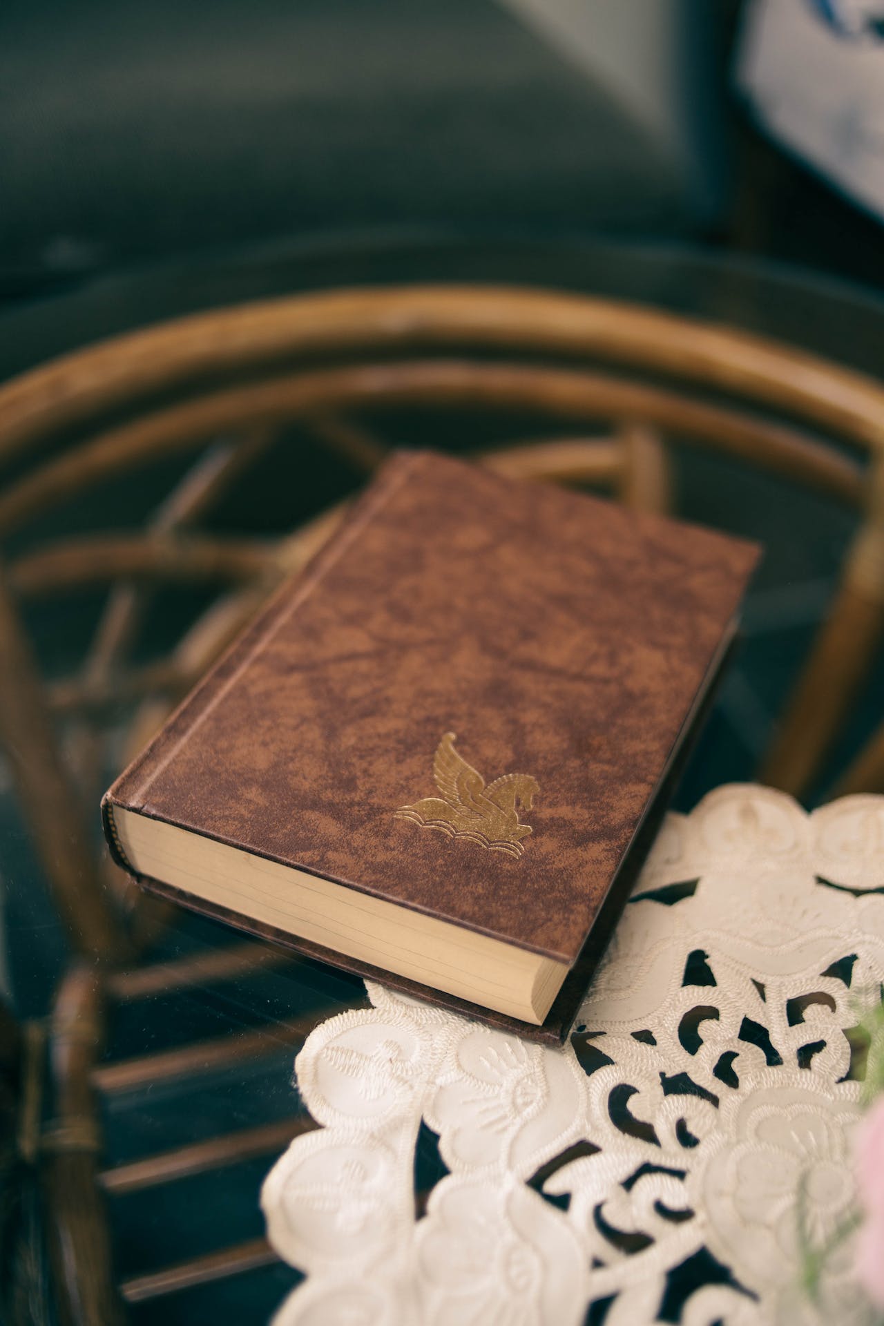 A brown hardcover book on a glass table